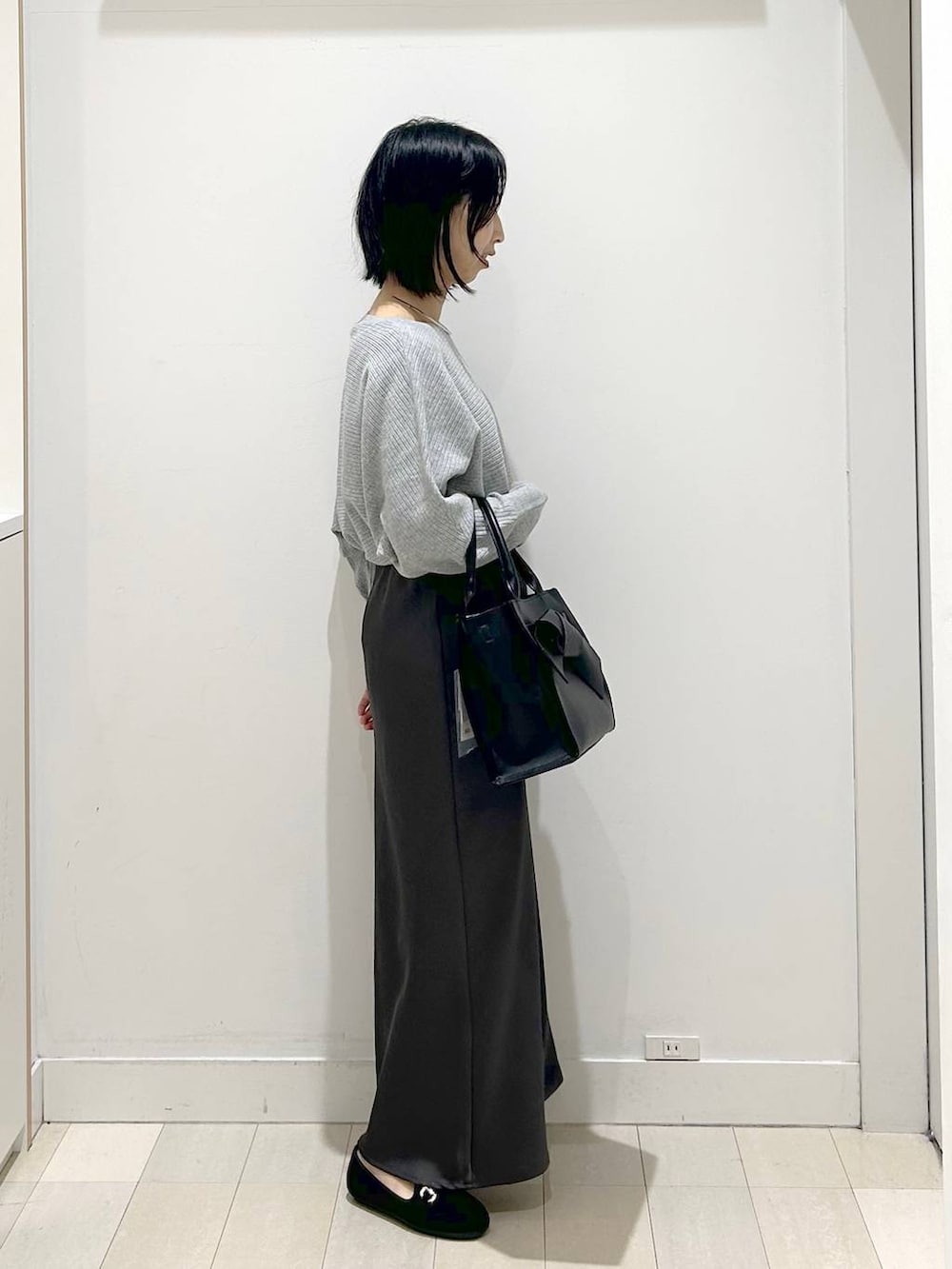 ブラック系のローファー、グレー系のニット/セーター、ブラック系のハンドバッグを着用したレディースの冬コーディネートの4枚目の写真