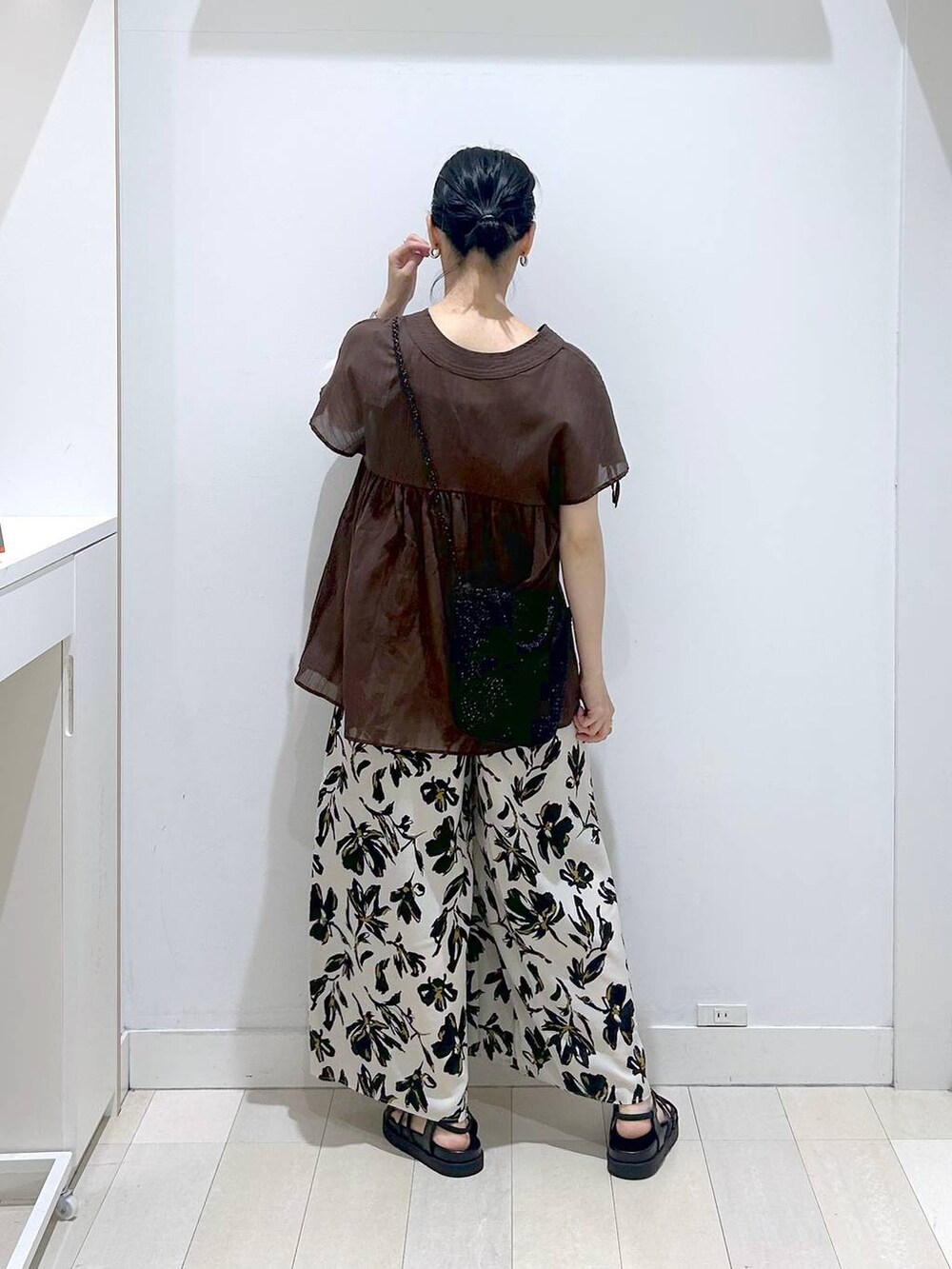 ホワイト系のその他パンツ、ブラウン系のシャツ/ブラウス、ブラック系のクラッチバッグを着用したレディースの春コーディネートの3枚目の写真