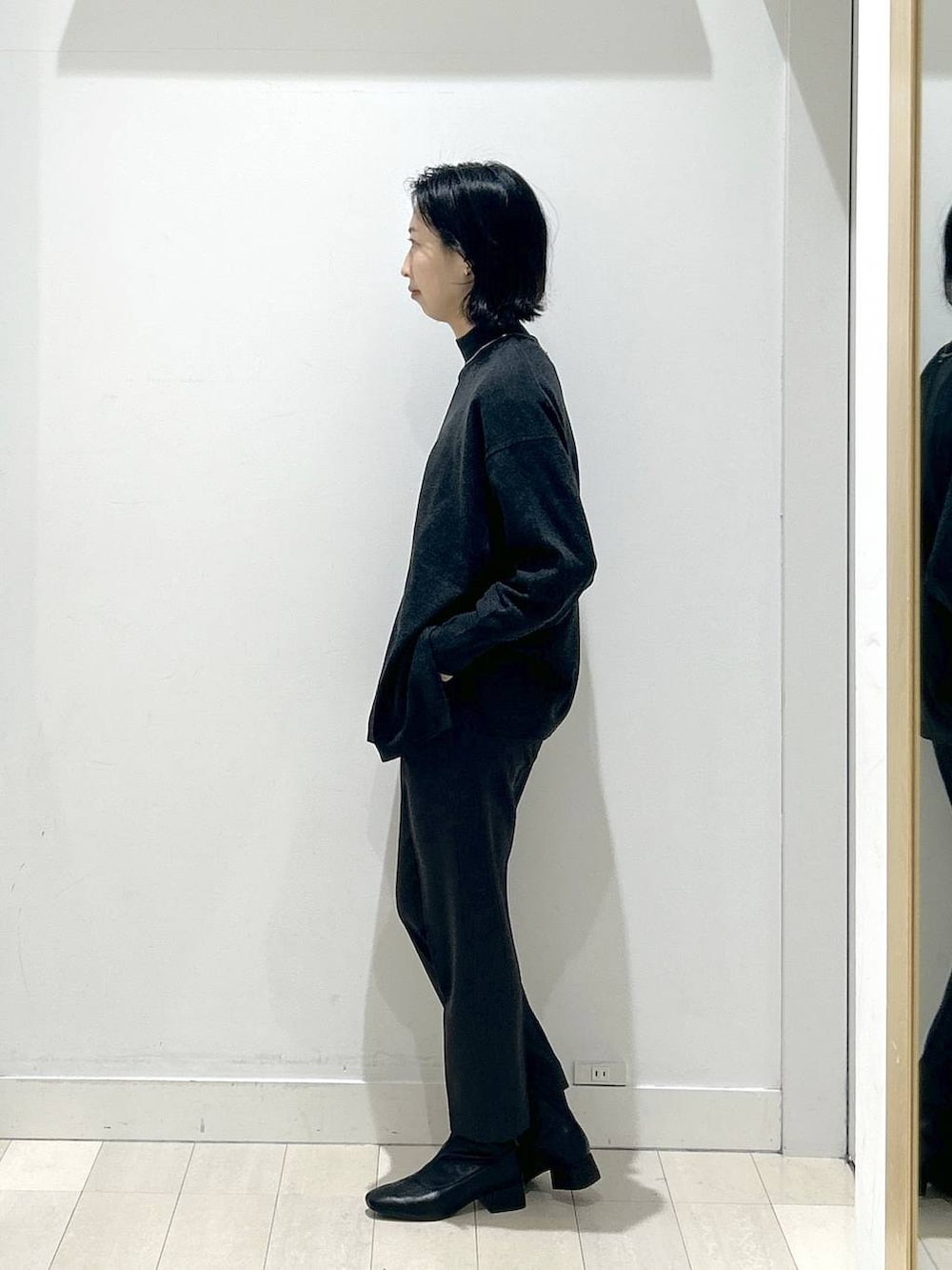 ブラウン系のチェスターコート、グレー系のその他パンツ、グレー系のニット/セーターを着用したレディースの冬コーディネートの7枚目の写真