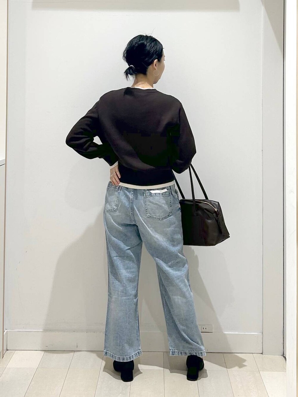 ブラック系のローファー、ブラック系のボストンバッグ、ブルー系のデニムパンツを着用したレディースの春コーディネートの3枚目の写真