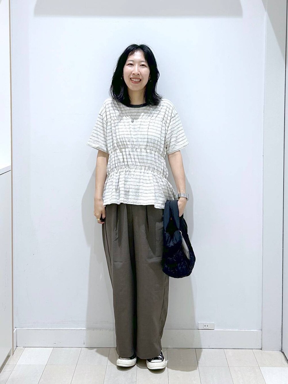 ブラック系のトートバッグ、ブラウン系のその他パンツ、ホワイト系のTシャツ/カットソーを着用したレディースの夏コーディネートの5枚目の写真