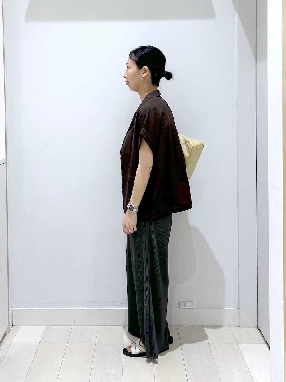 イエロー系のショルダーバッグ、ホワイト系のタンクトップ、ブラック系のその他パンツを着用したレディースの夏コーディネートの2枚目の写真
