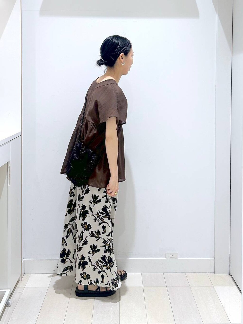 ホワイト系のその他パンツ、ブラウン系のシャツ/ブラウス、ブラック系のクラッチバッグを着用したレディースの春コーディネートの4枚目の写真