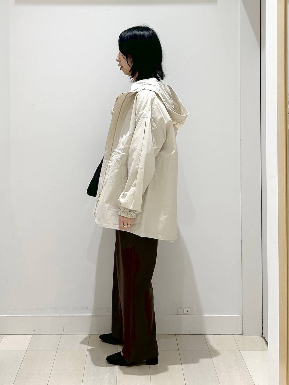 ブラック系のトートバッグ、ベージュ系のパーカー、ブラウン系のその他パンツを着用したレディースの春コーディネートの3枚目の写真