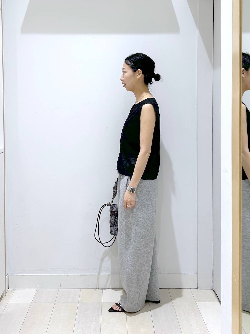 グレー系のトートバッグ、グレー系のその他パンツ、ブラック系のベストを着用したレディースの夏コーディネートの2枚目の写真