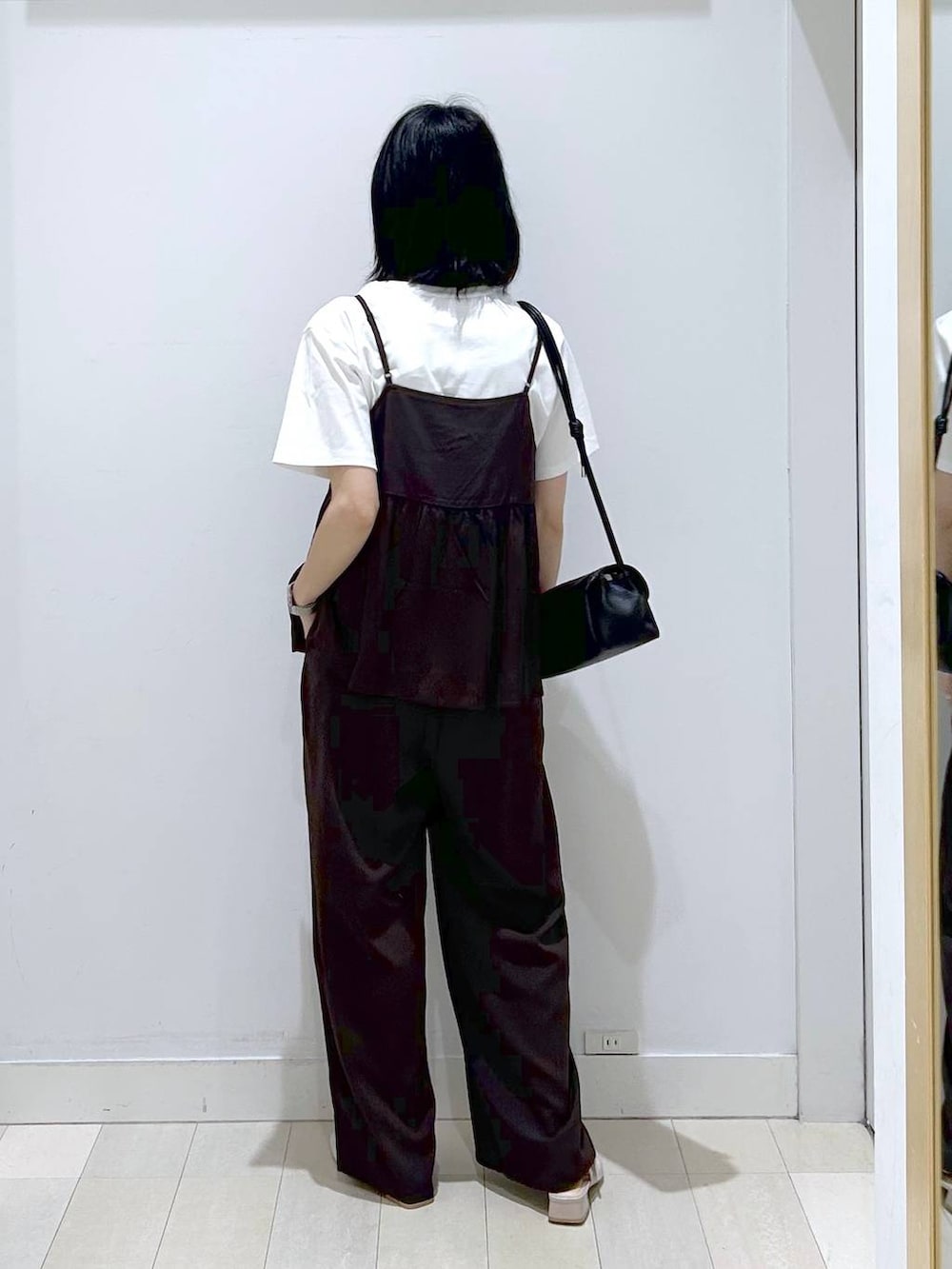 ブラック系のショルダーバッグ、ブラウン系のその他パンツ、ブラック系のTシャツ/カットソーを着用したレディースの春コーディネートの3枚目の写真