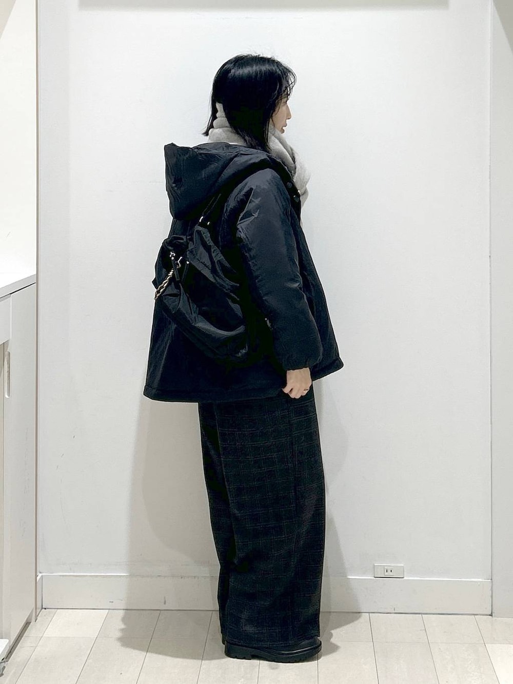 ブラック系のショルダーバッグ、ブラック系のダウンジャケット/コート、ブラック系のブーツを着用したレディースの冬コーディネートの2枚目の写真