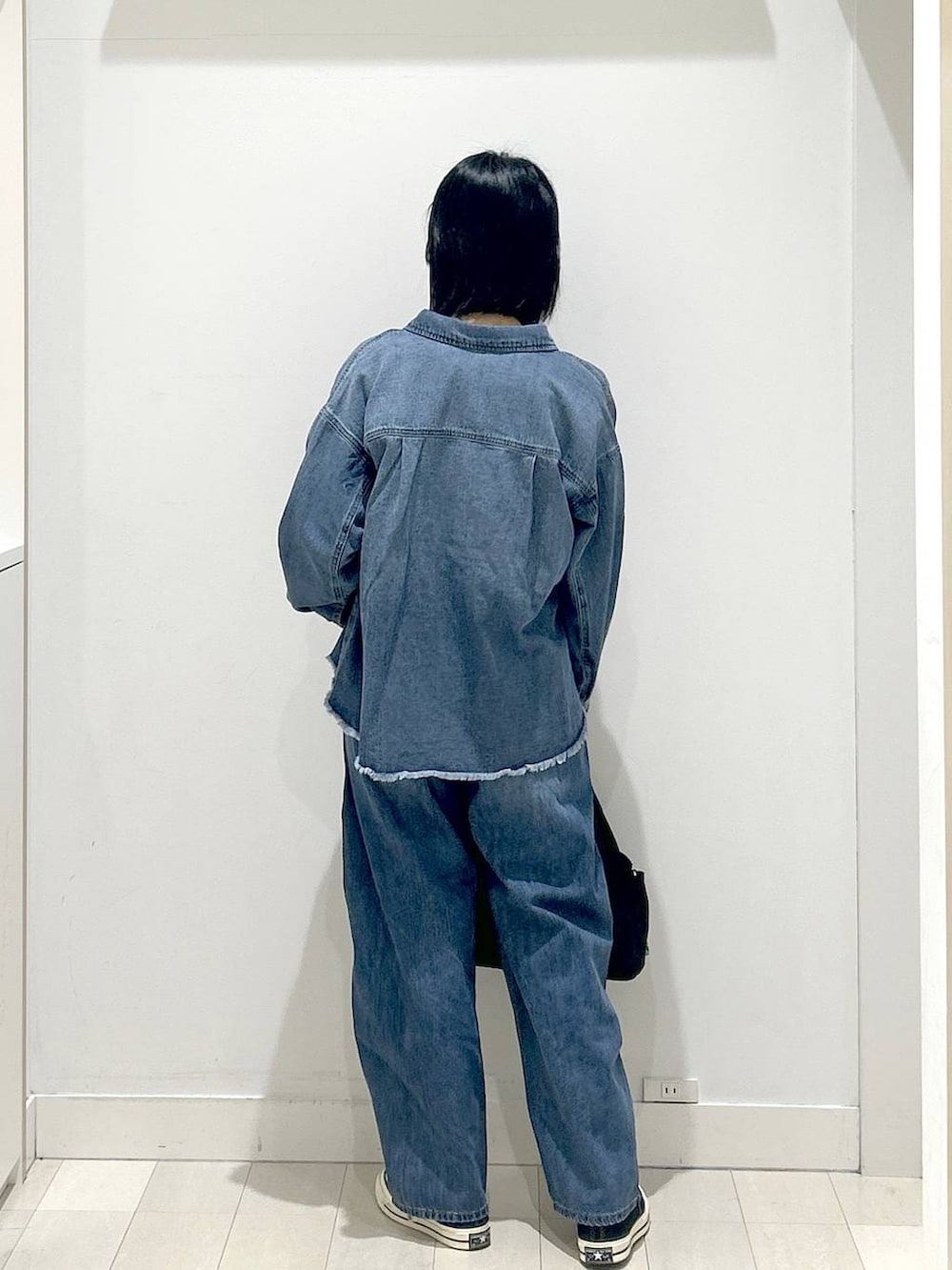 ブラック系のトートバッグ、ブルー系のシャツ/ブラウス、グレー系のニット/セーターを着用したレディースの冬コーディネートの3枚目の写真