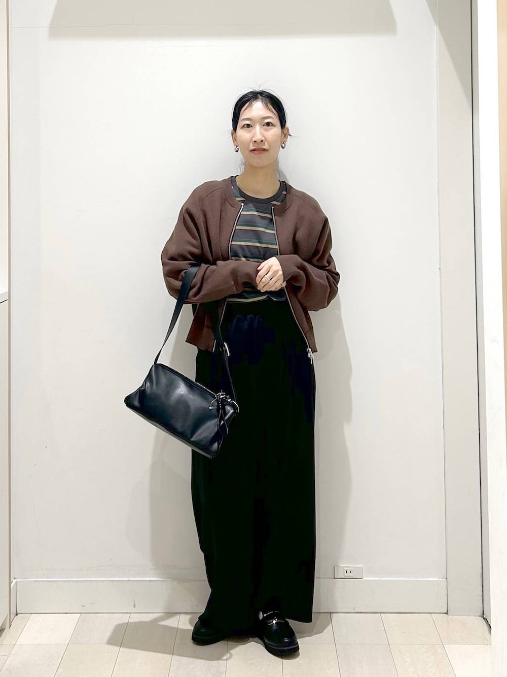 ブラック系のローファー、ブラウン系のカーディガン/ボレロ、ブラック系のショルダーバッグを着用したレディースの春コーディネートの5枚目の写真