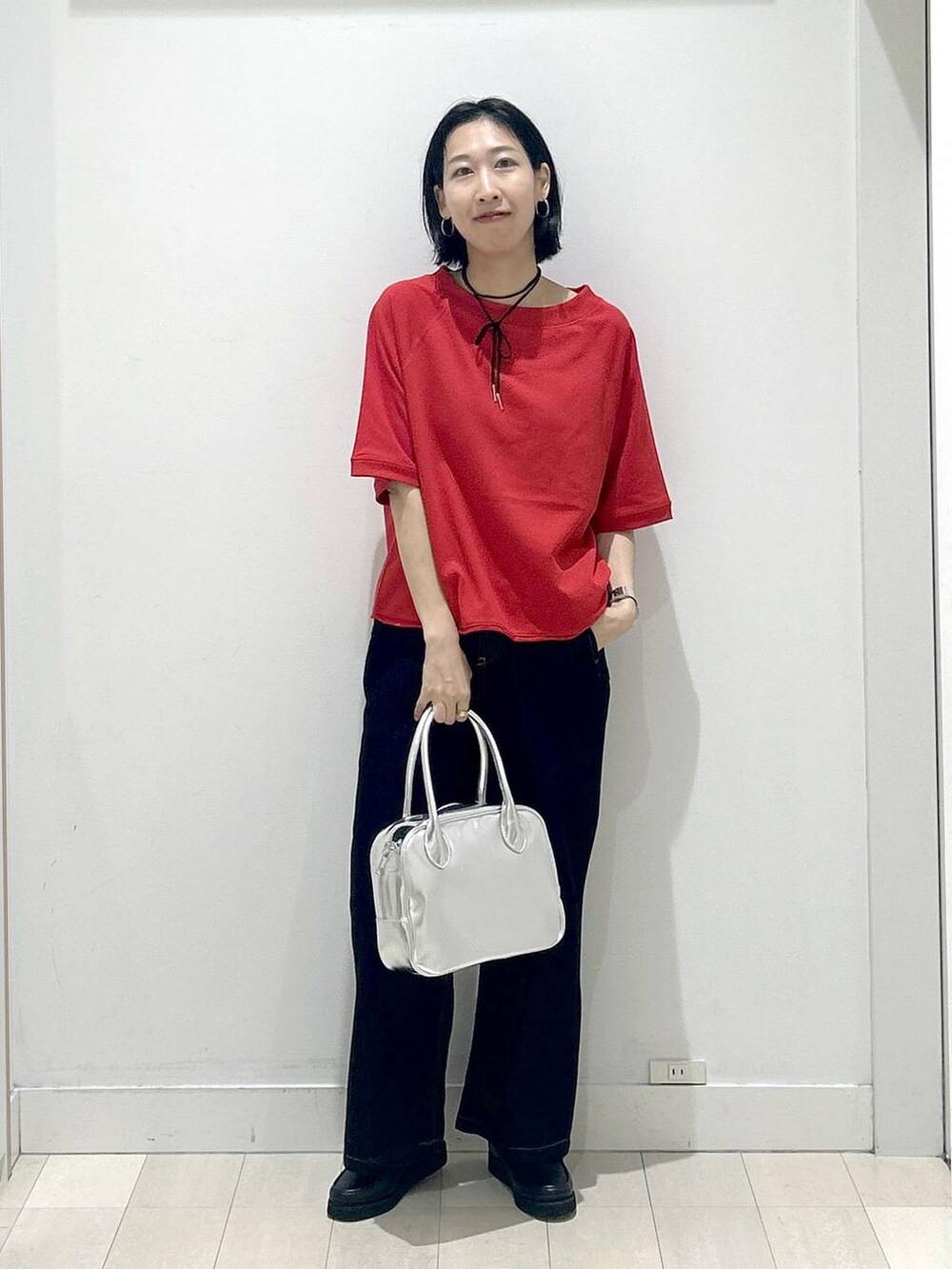 ブラック系のローファー、グレー系のボストンバッグ、ブルー系のデニムパンツを着用したレディースの秋コーディネートの5枚目の写真