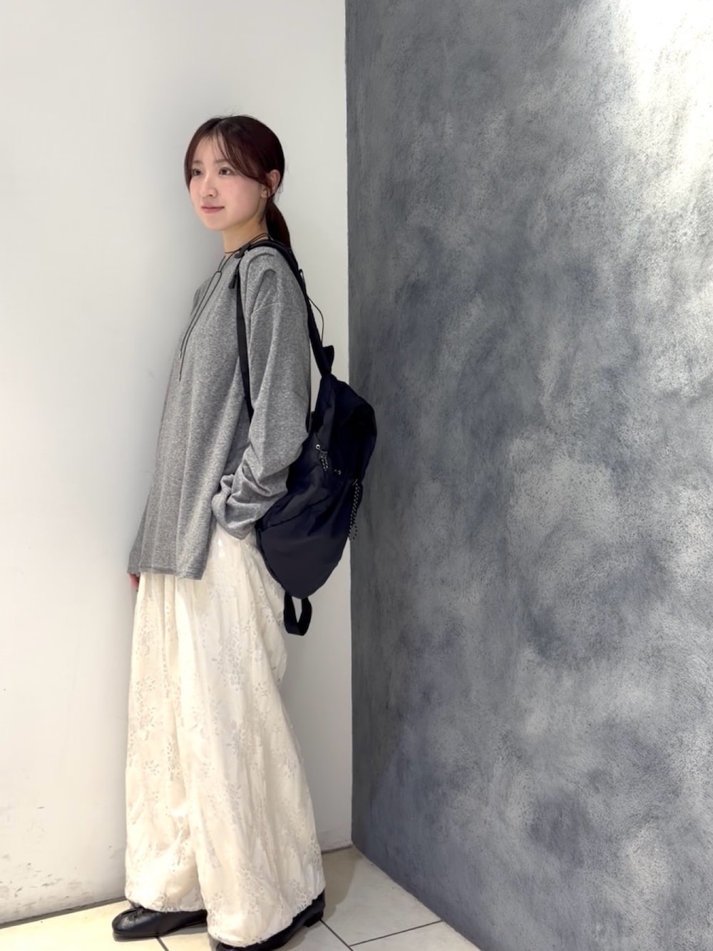 グレー系のTシャツ/カットソー、ブラック系のバックパック/リュック、ホワイト系のその他パンツを着用したレディースの春コーディネートの2枚目の写真