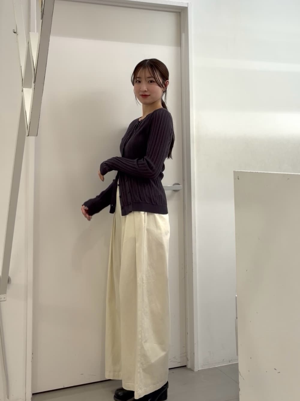 グレー系のニット/セーター、ホワイト系のその他パンツ、ブラック系のサンダルを着用したレディースの春コーディネートの2枚目の写真