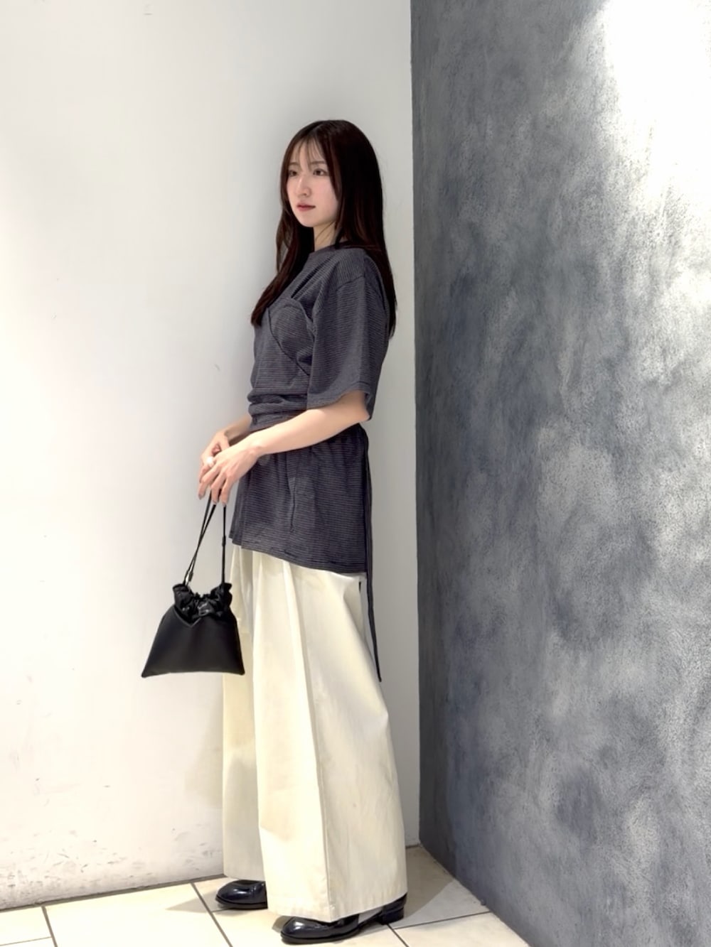 グレー系のTシャツ/カットソー、ホワイト系のその他パンツ、ブラック系のショルダーバッグを着用したレディースの春コーディネートの2枚目の写真