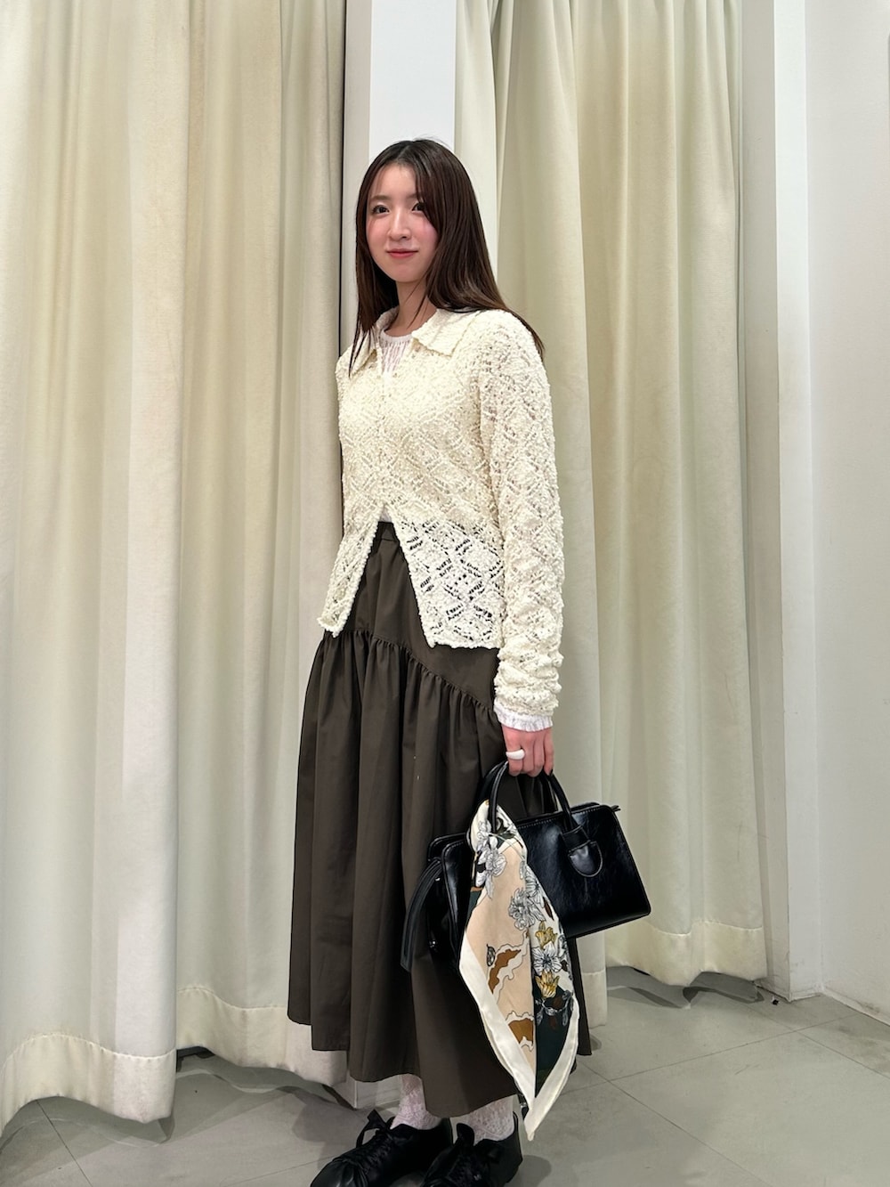 ホワイト系のTシャツ/カットソー、ホワイト系のニット/セーター、グリーン系のスカートを着用したレディースの冬コーディネートの2枚目の写真