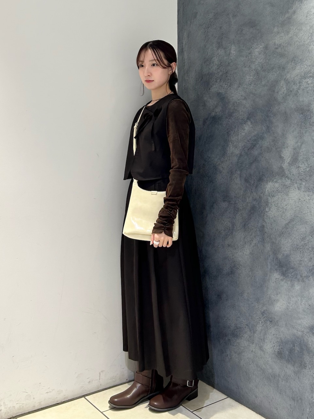 ブラウン系のワンピース、ブラウン系のTシャツ/カットソー、ホワイト系のショルダーバッグを着用したレディースの秋コーディネートの2枚目の写真