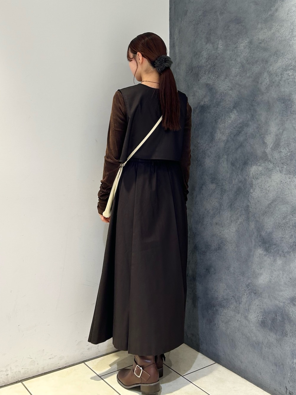 ブラウン系のワンピース、ブラウン系のTシャツ/カットソー、ホワイト系のショルダーバッグを着用したレディースの秋コーディネートの3枚目の写真