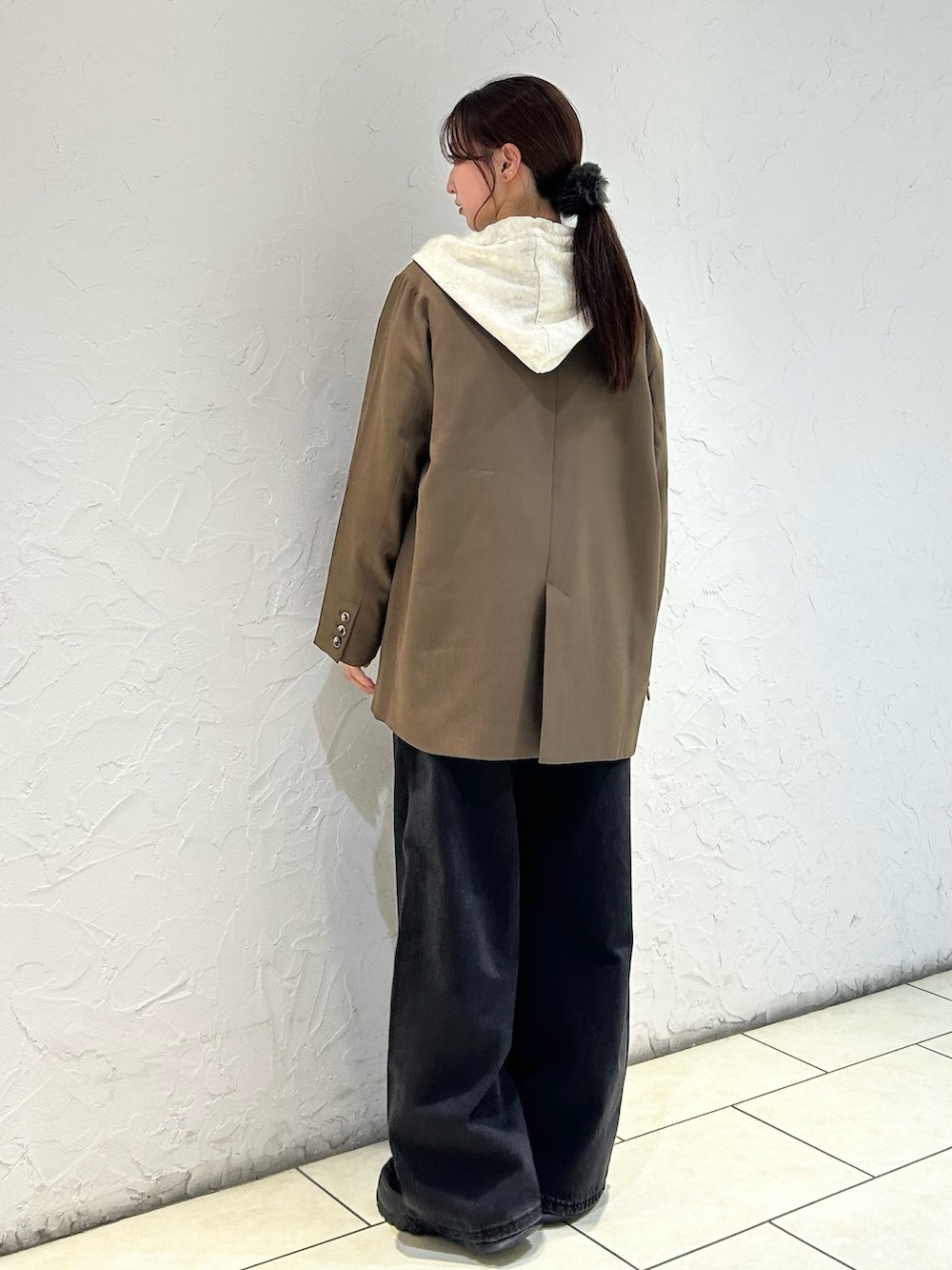 ホワイト系のパーカー、ブラウン系のその他アウター、ブラック系のデニムパンツを着用したレディースの秋コーディネートの4枚目の写真