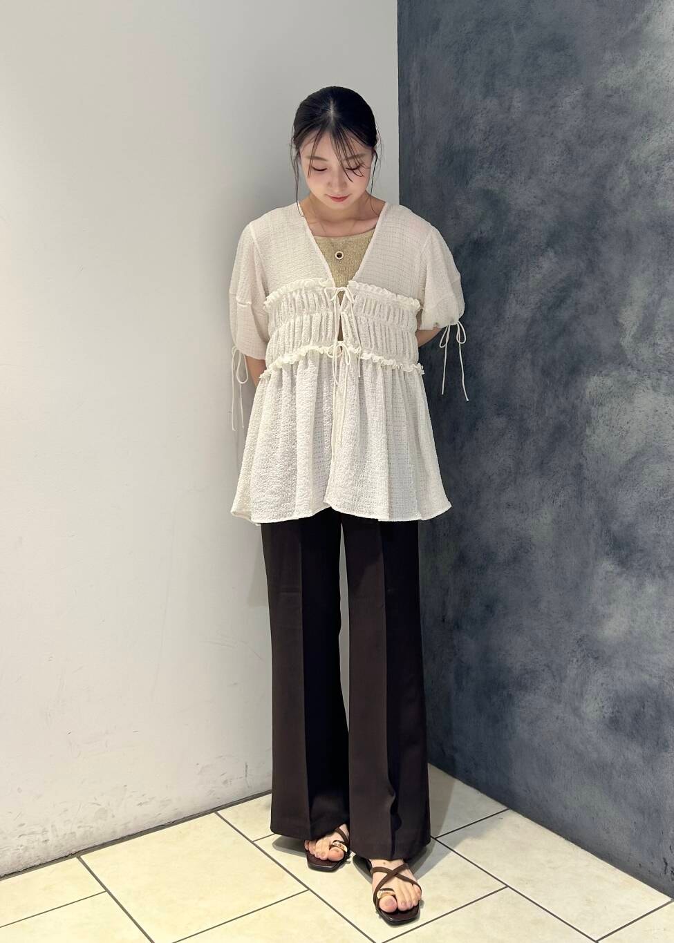 ブラウン系のサンダル、ブラウン系のその他パンツ、ホワイト系のシャツ/ブラウスを着用したレディースの夏コーディネートの2枚目の写真