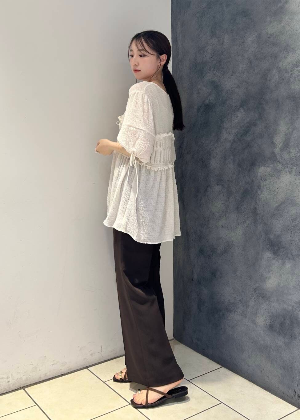 ブラウン系のサンダル、ブラウン系のその他パンツ、ホワイト系のシャツ/ブラウスを着用したレディースの夏コーディネートの3枚目の写真