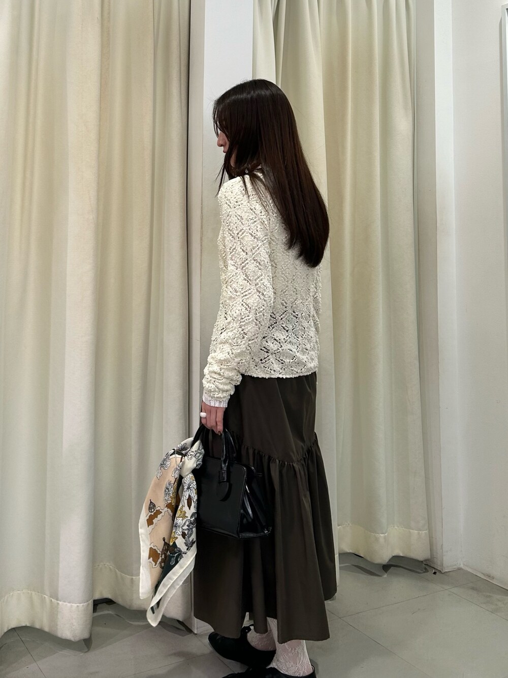 ホワイト系のTシャツ/カットソー、ホワイト系のニット/セーター、グリーン系のスカートを着用したレディースの冬コーディネートの3枚目の写真