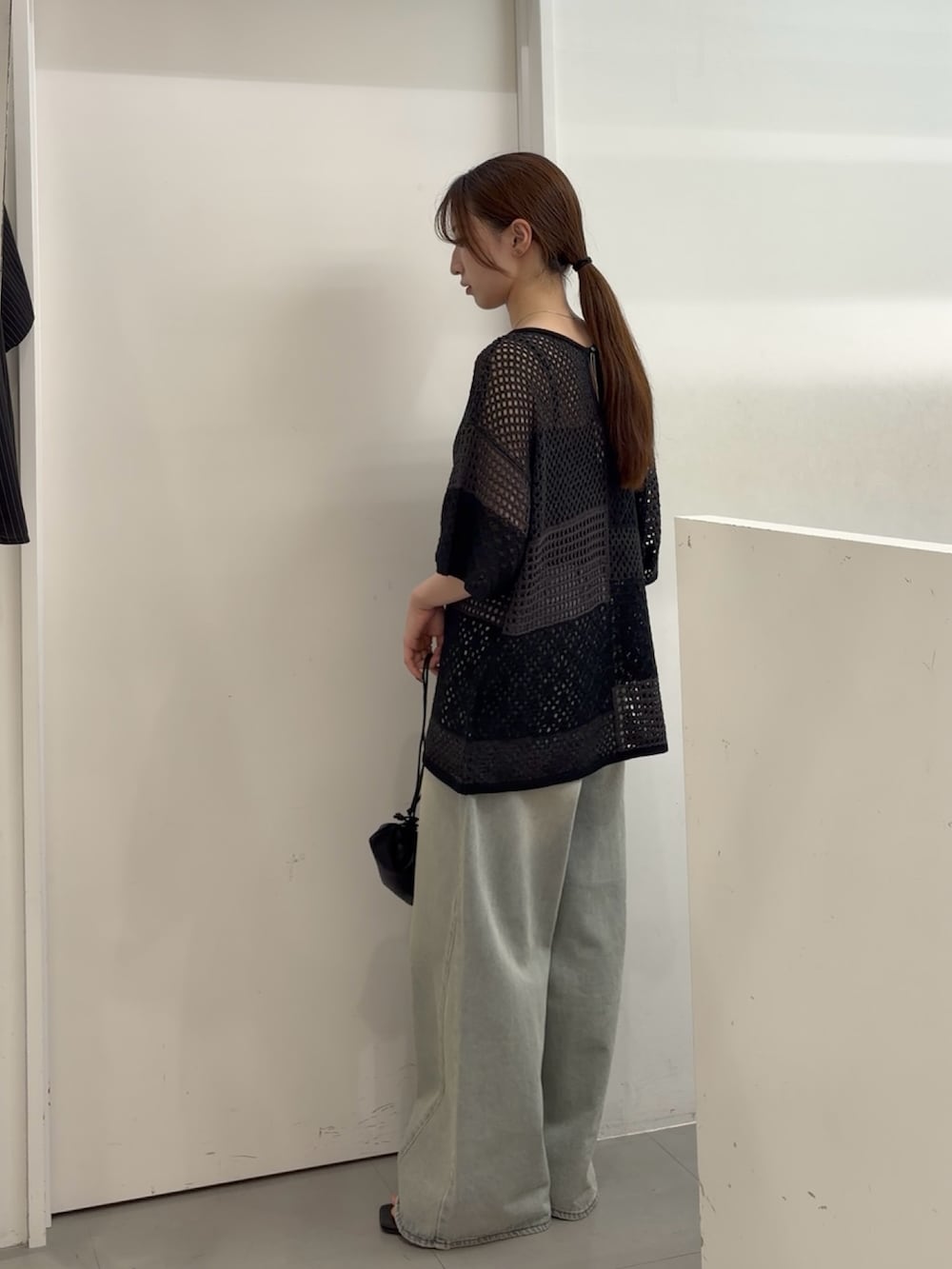 グレー系のニット/セーター、ブルー系のデニムパンツ、ブラック系のサンダルを着用したレディースの夏コーディネートの3枚目の写真