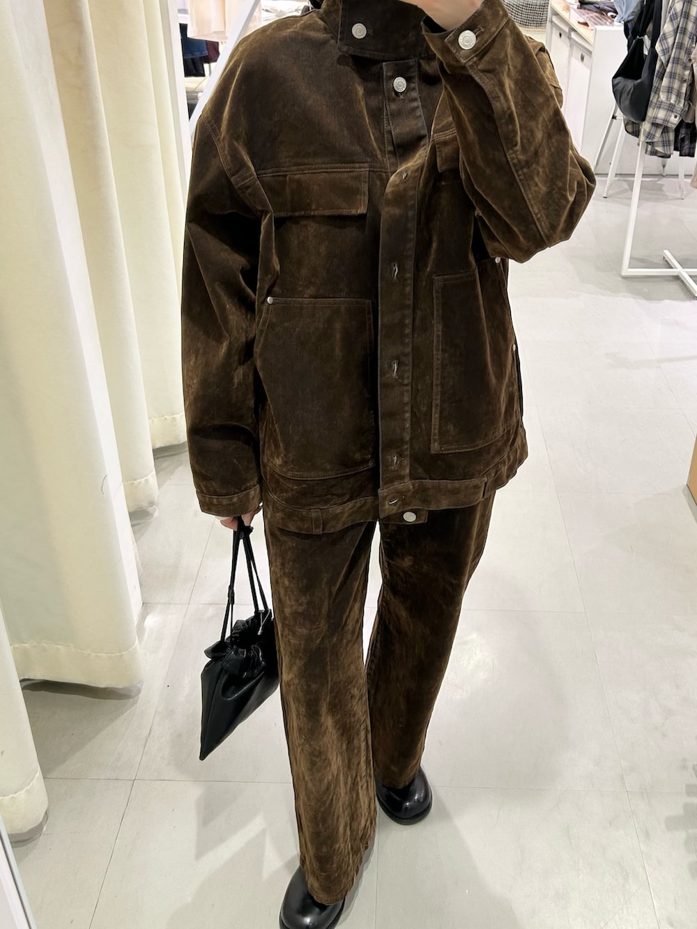 ブラウン系のブルゾン、ブラウン系のデニムパンツ、ブラック系のサンダルを着用したレディースの冬コーディネートの6枚目の写真