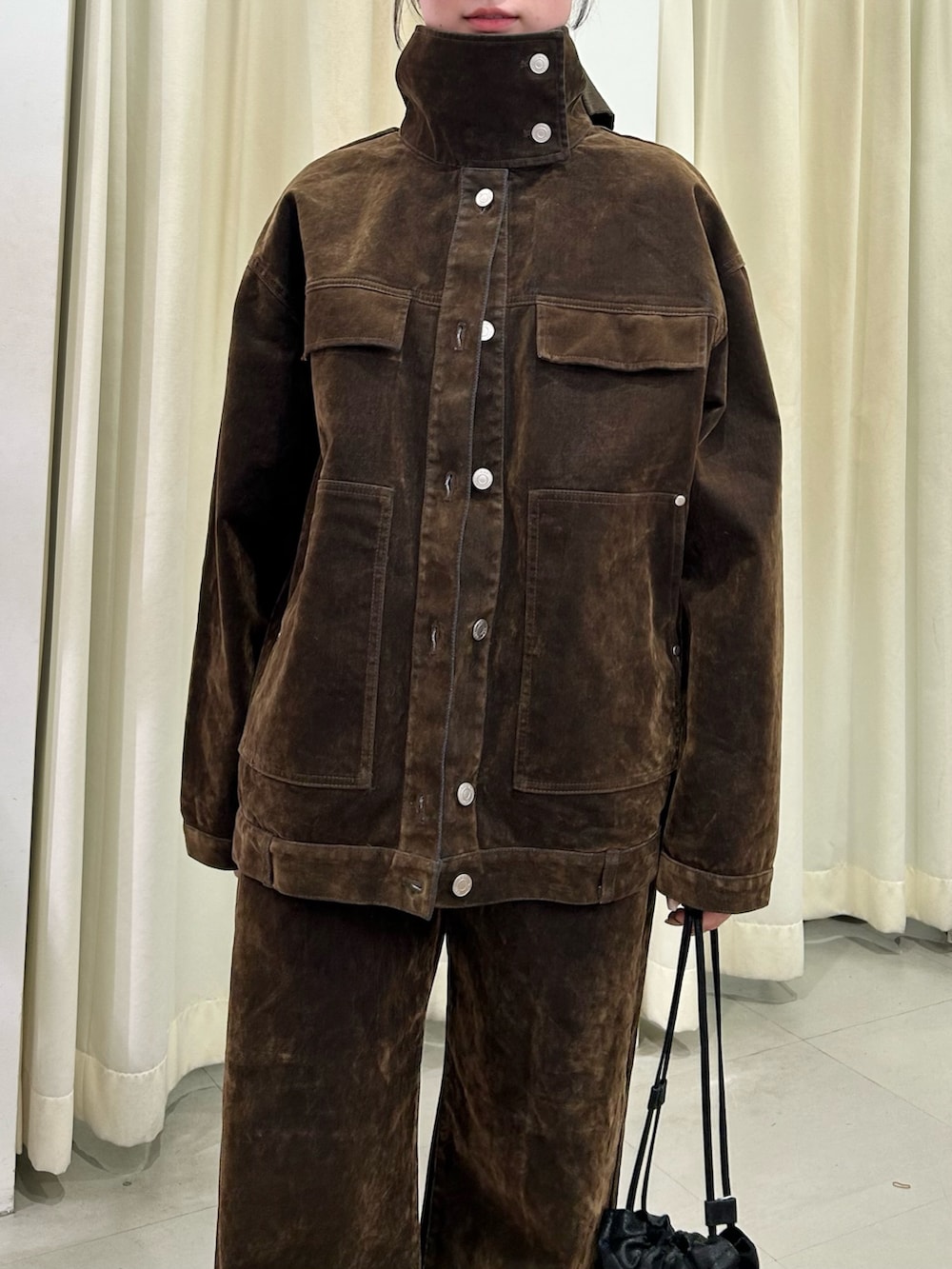 ブラウン系のブルゾン、ブラウン系のデニムパンツ、ブラック系のサンダルを着用したレディースの冬コーディネートの4枚目の写真