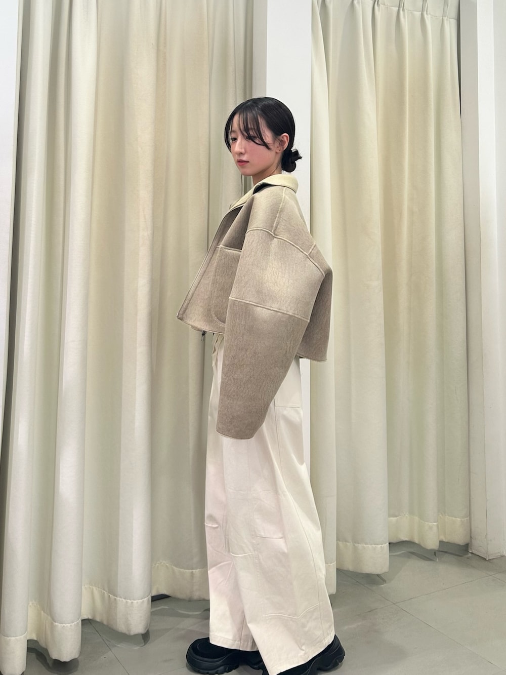 ベージュ系のその他アウター、ブラウン系のTシャツ/カットソー、ホワイト系のその他パンツを着用したレディースの冬コーディネートの2枚目の写真