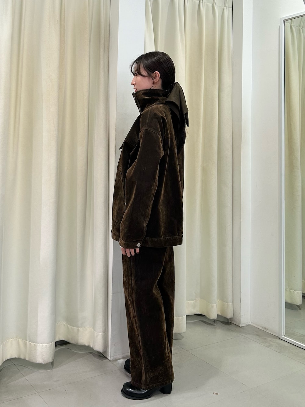 ブラウン系のブルゾン、ブラウン系のデニムパンツ、ブラック系のサンダルを着用したレディースの冬コーディネートの2枚目の写真