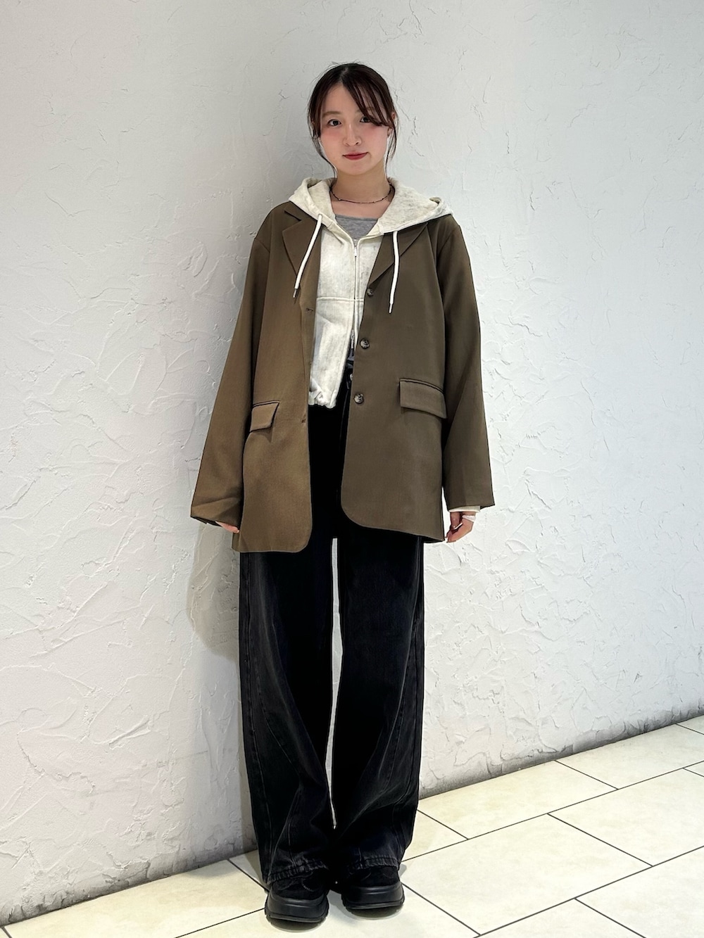 ホワイト系のパーカー、ブラウン系のその他アウター、ブラック系のデニムパンツを着用したレディースの秋コーディネートの2枚目の写真