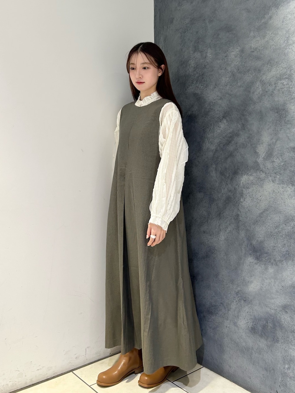 ブラウン系のワンピース、ホワイト系のシャツ/ブラウス、ブラウン系のブーツを着用したレディースの秋コーディネートの2枚目の写真