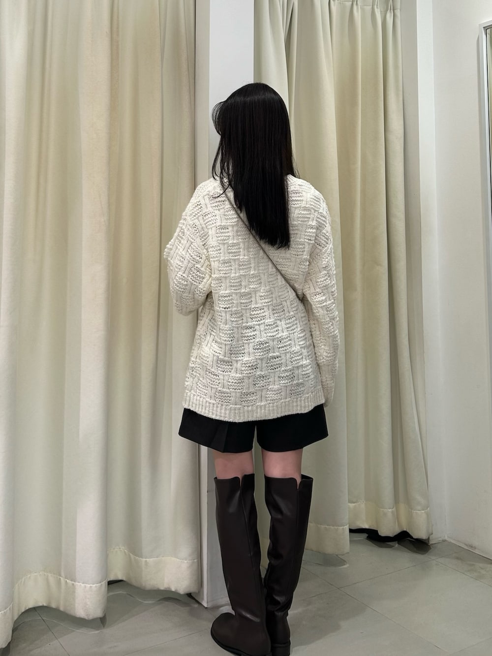 ホワイト系のニット/セーター、ブラウン系のその他パンツ、ブラウン系のブーツを着用したレディースの秋コーディネートの3枚目の写真