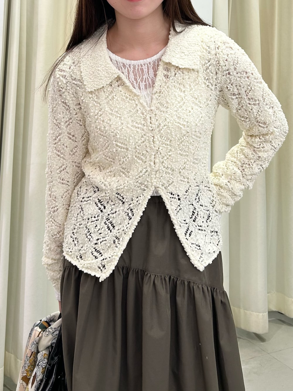 ホワイト系のTシャツ/カットソー、ホワイト系のニット/セーター、グリーン系のスカートを着用したレディースの冬コーディネートの4枚目の写真