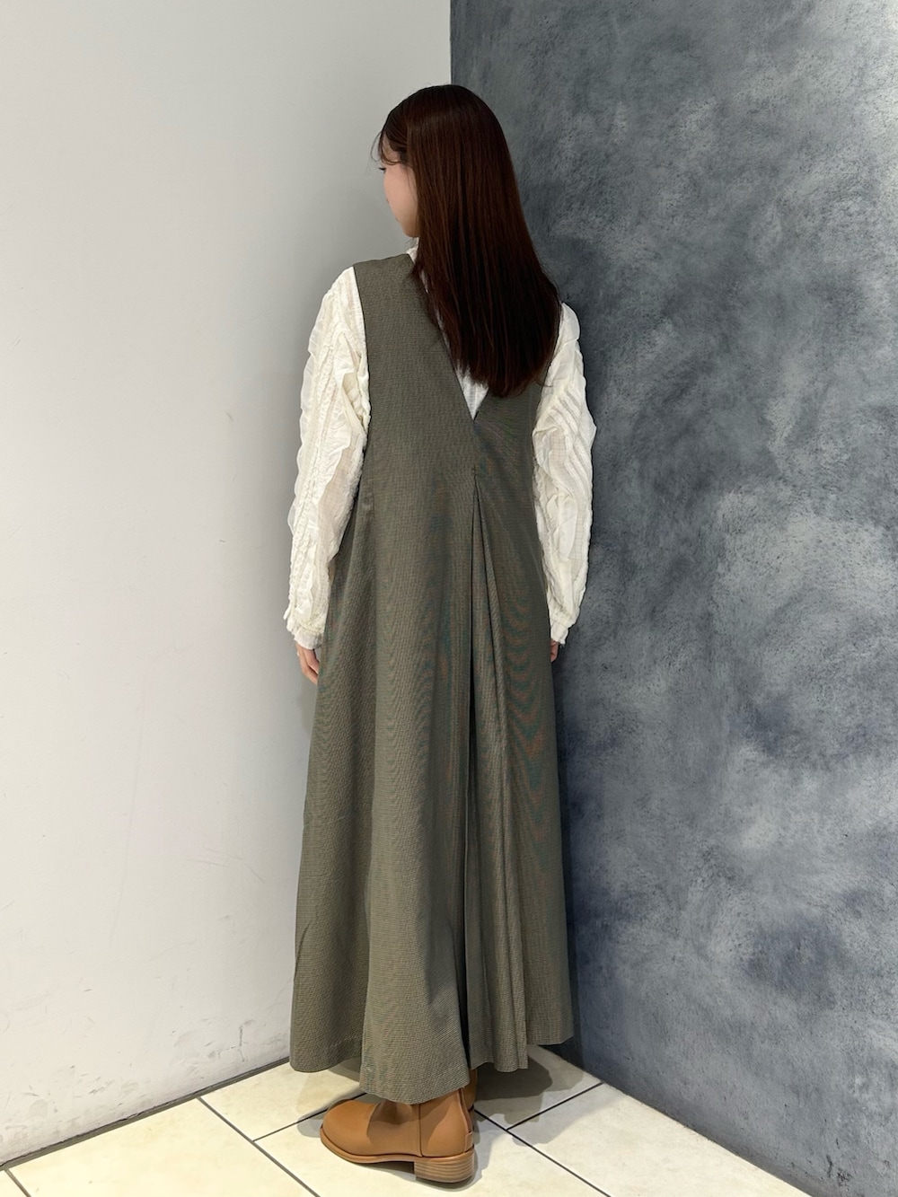 ブラウン系のワンピース、ホワイト系のシャツ/ブラウス、ブラウン系のブーツを着用したレディースの秋コーディネートの3枚目の写真