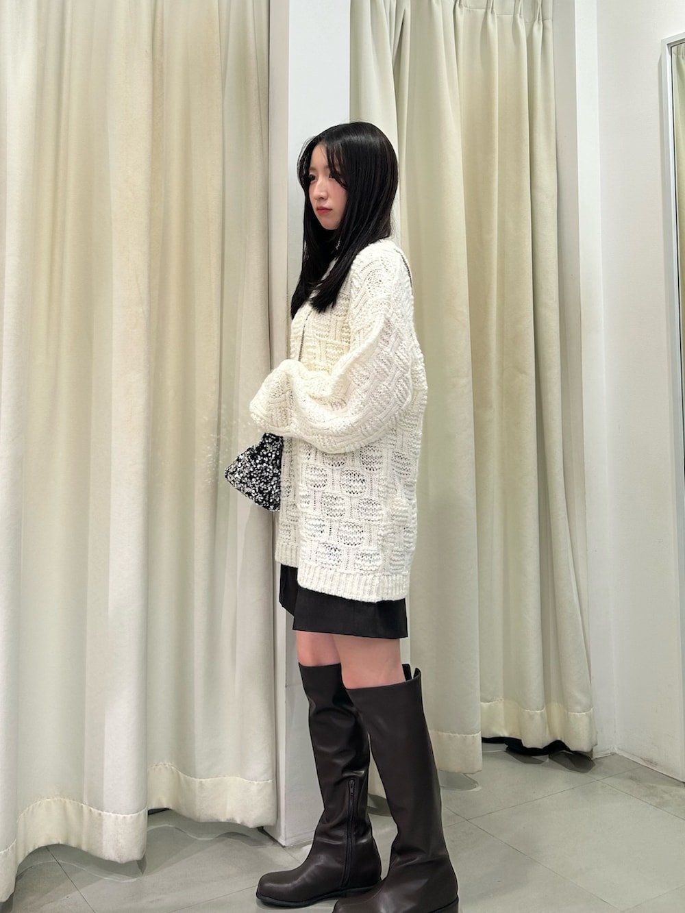 ホワイト系のニット/セーター、ブラウン系のその他パンツ、ブラウン系のブーツを着用したレディースの秋コーディネートの2枚目の写真