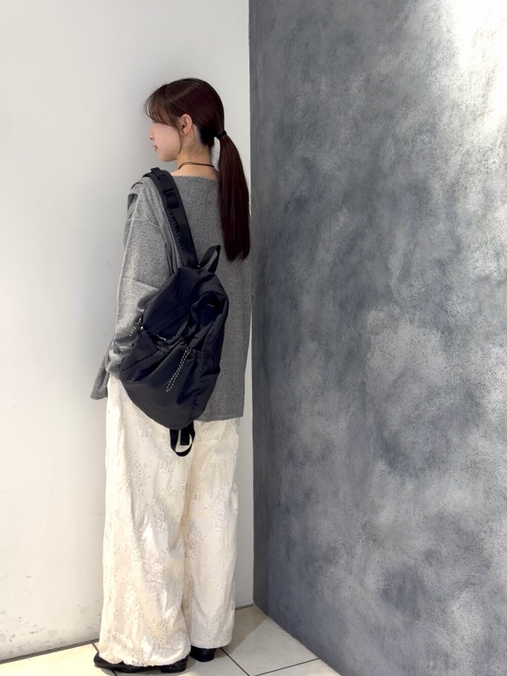 グレー系のTシャツ/カットソー、ブラック系のバックパック/リュック、ホワイト系のその他パンツを着用したレディースの春コーディネートの4枚目の写真