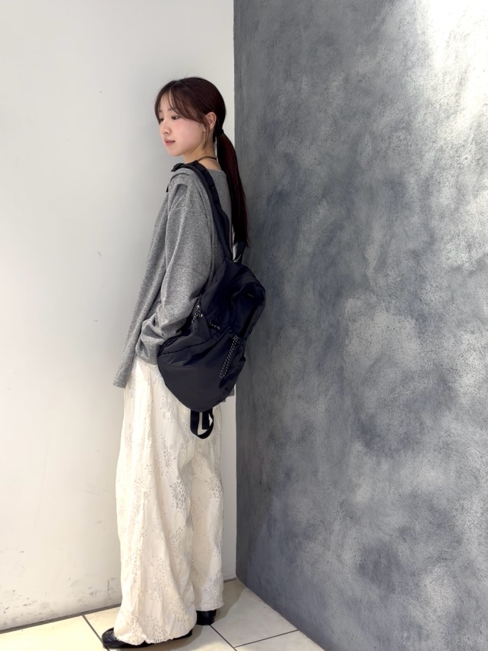 グレー系のTシャツ/カットソー、ブラック系のバックパック/リュック、ホワイト系のその他パンツを着用したレディースの春コーディネートの3枚目の写真