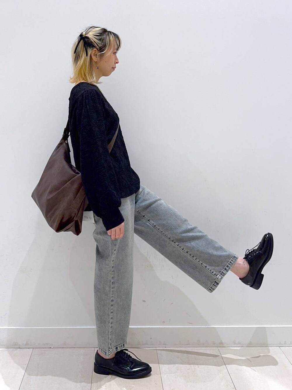 ブルー系のデニムパンツ、ブラック系のその他シューズ、ブラウン系のショルダーバッグを着用したレディースの冬コーディネートの2枚目の写真