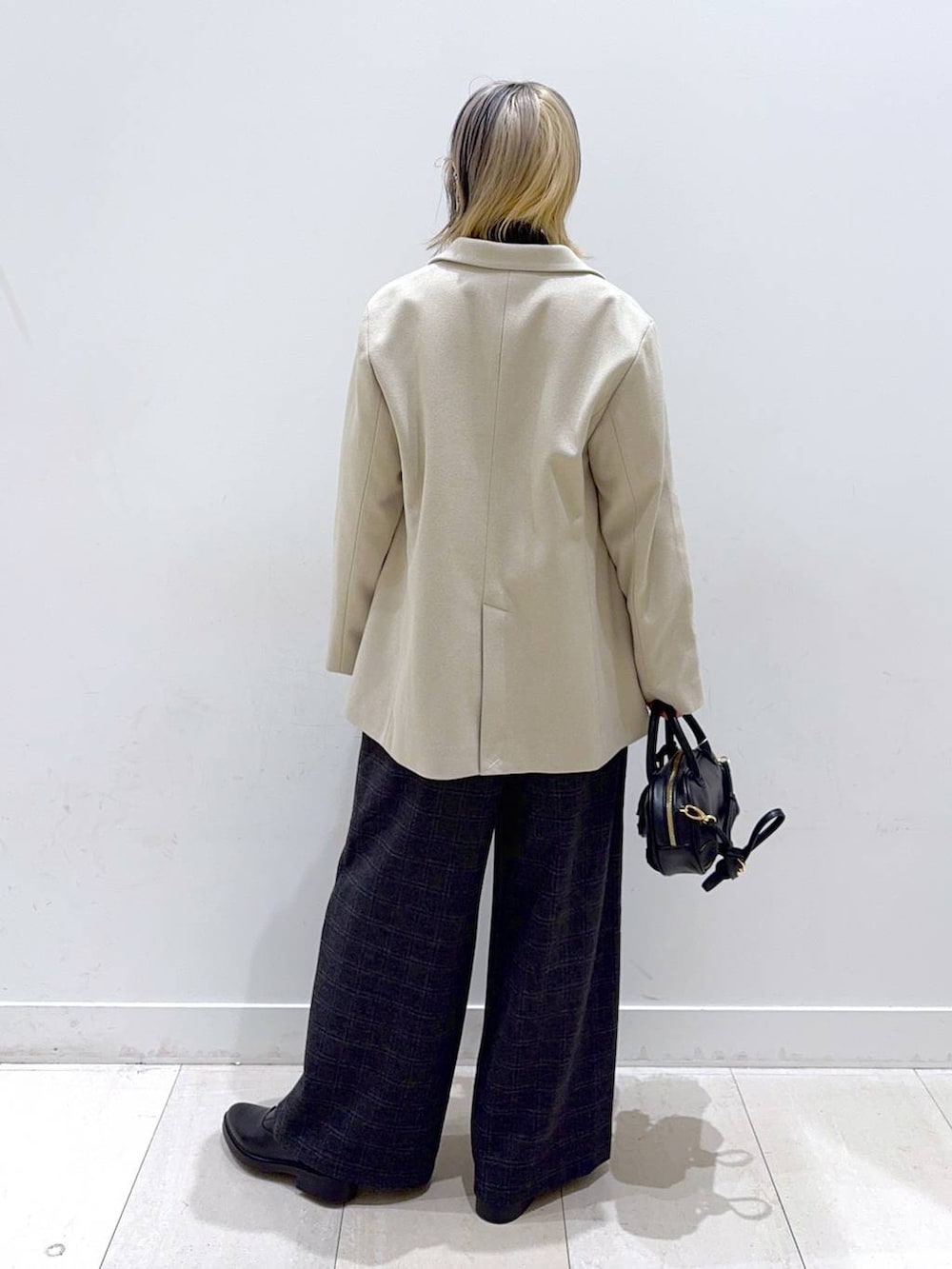 グレー系のニット/セーター、グレー系のその他パンツ、ブラック系のハンドバッグを着用したレディースの秋コーディネートの3枚目の写真