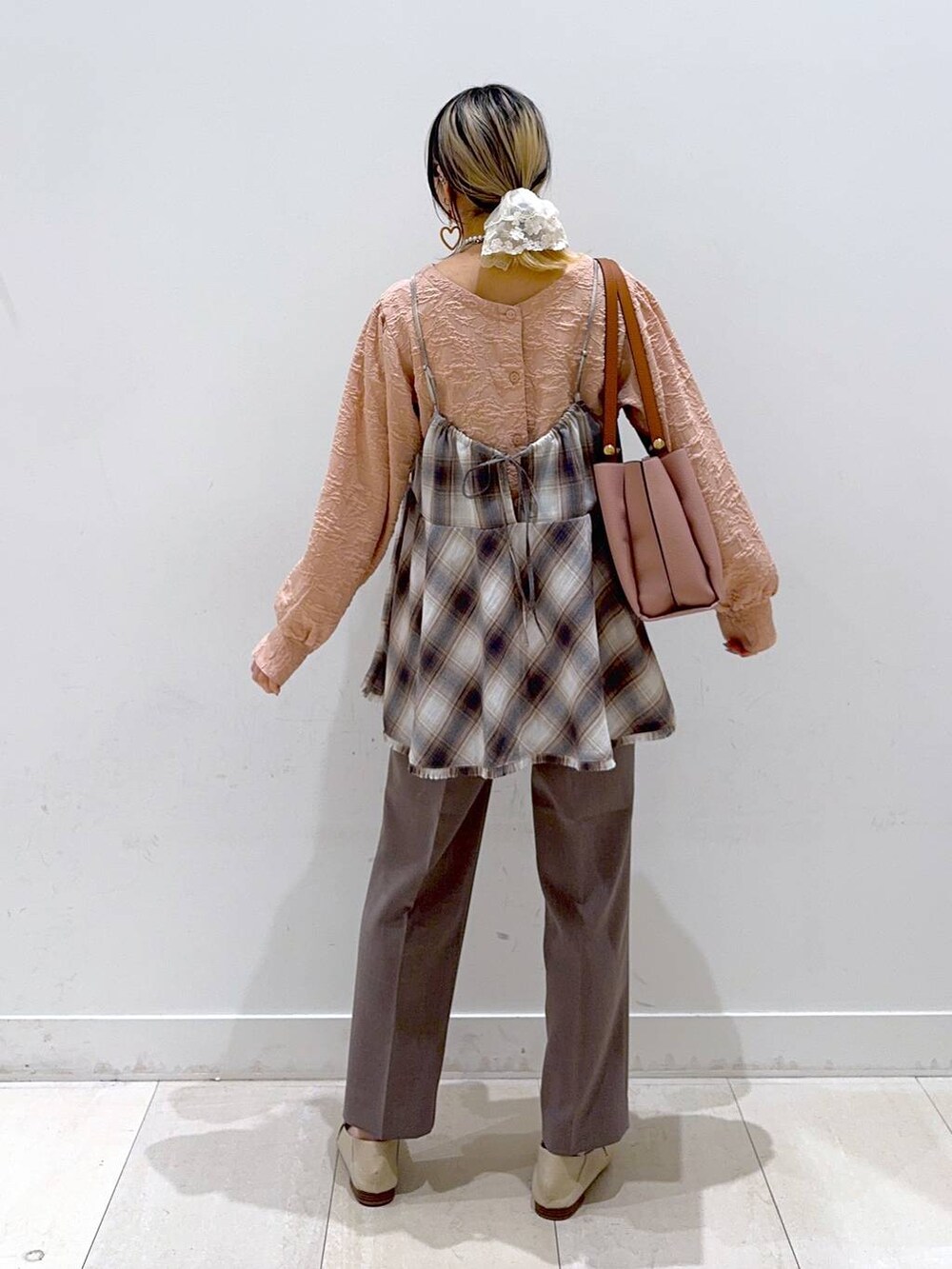 ピンク系のトートバッグ、ブラウン系のその他パンツ、ホワイト系のその他トップスを着用したレディースの春コーディネートの3枚目の写真