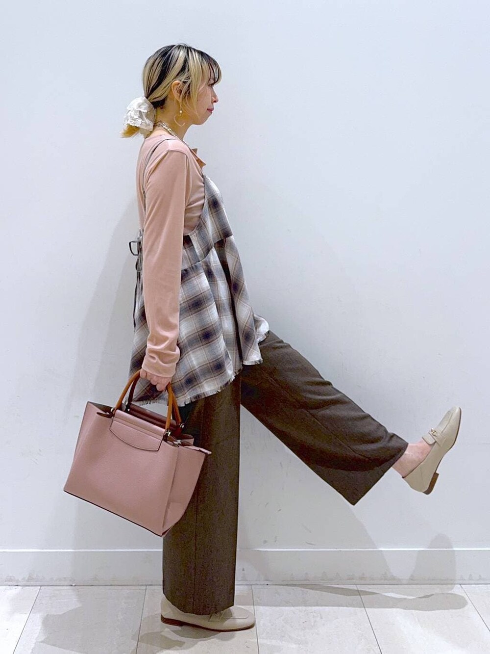 ブラウン系のその他パンツ、ピンク系のトートバッグ、ホワイト系のその他トップスを着用したレディースの春コーディネートの2枚目の写真