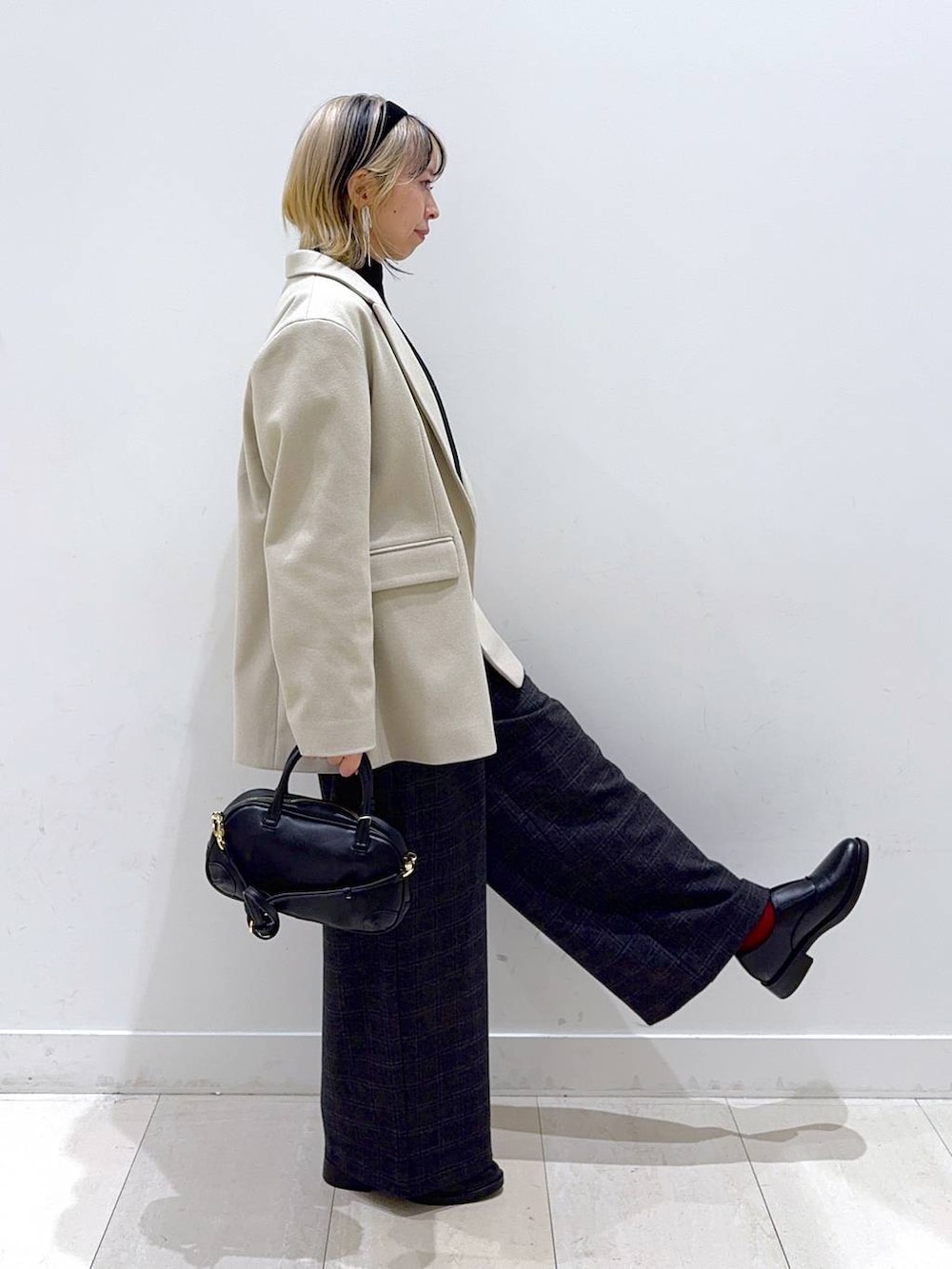 グレー系のニット/セーター、グレー系のその他パンツ、ブラック系のハンドバッグを着用したレディースの秋コーディネートの2枚目の写真