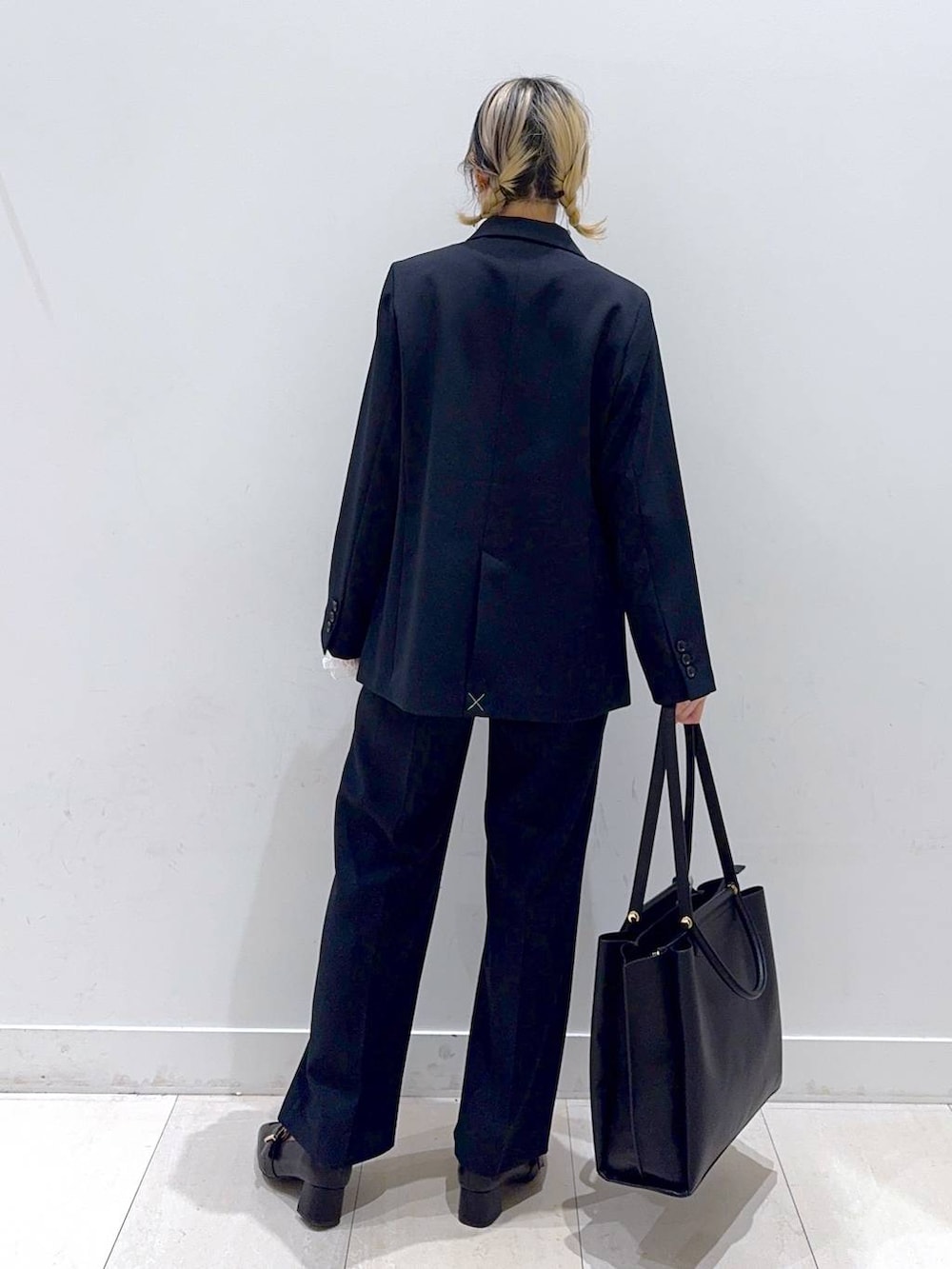 ブラック系のローファー、ホワイト系のTシャツ/カットソー、ブルー系のテーラードジャケットを着用したレディースの冬コーディネートの3枚目の写真