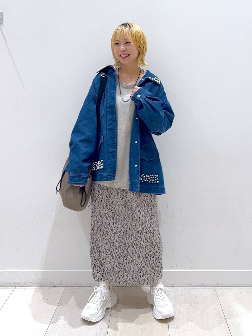 グレー系のバックパック/リュック、ホワイト系のスニーカー、ベージュ系のニット/セーターを着用したレディースの秋コーディネートの4枚目の写真