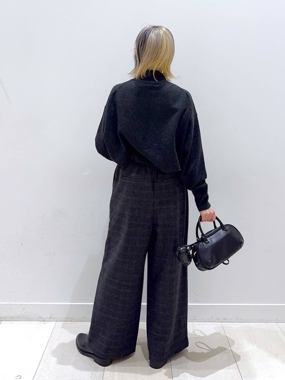 グレー系のニット/セーター、グレー系のその他パンツ、ブラック系のハンドバッグを着用したレディースの秋コーディネートの5枚目の写真