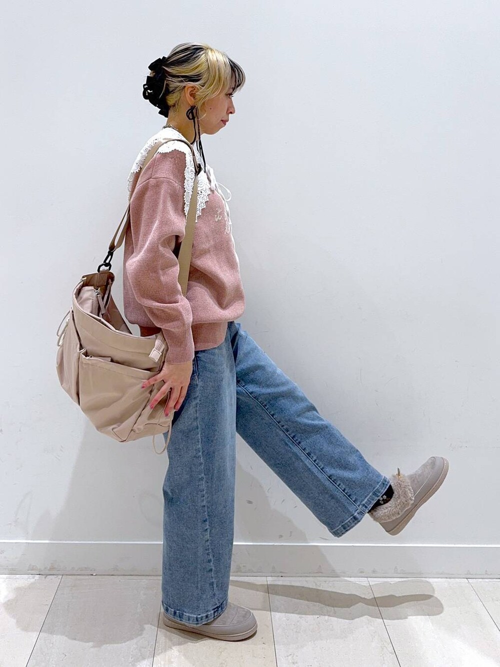 ベージュ系のショルダーバッグ、ブルー系のデニムパンツ、グレー系のその他シューズを着用したレディースの秋コーディネートの2枚目の写真