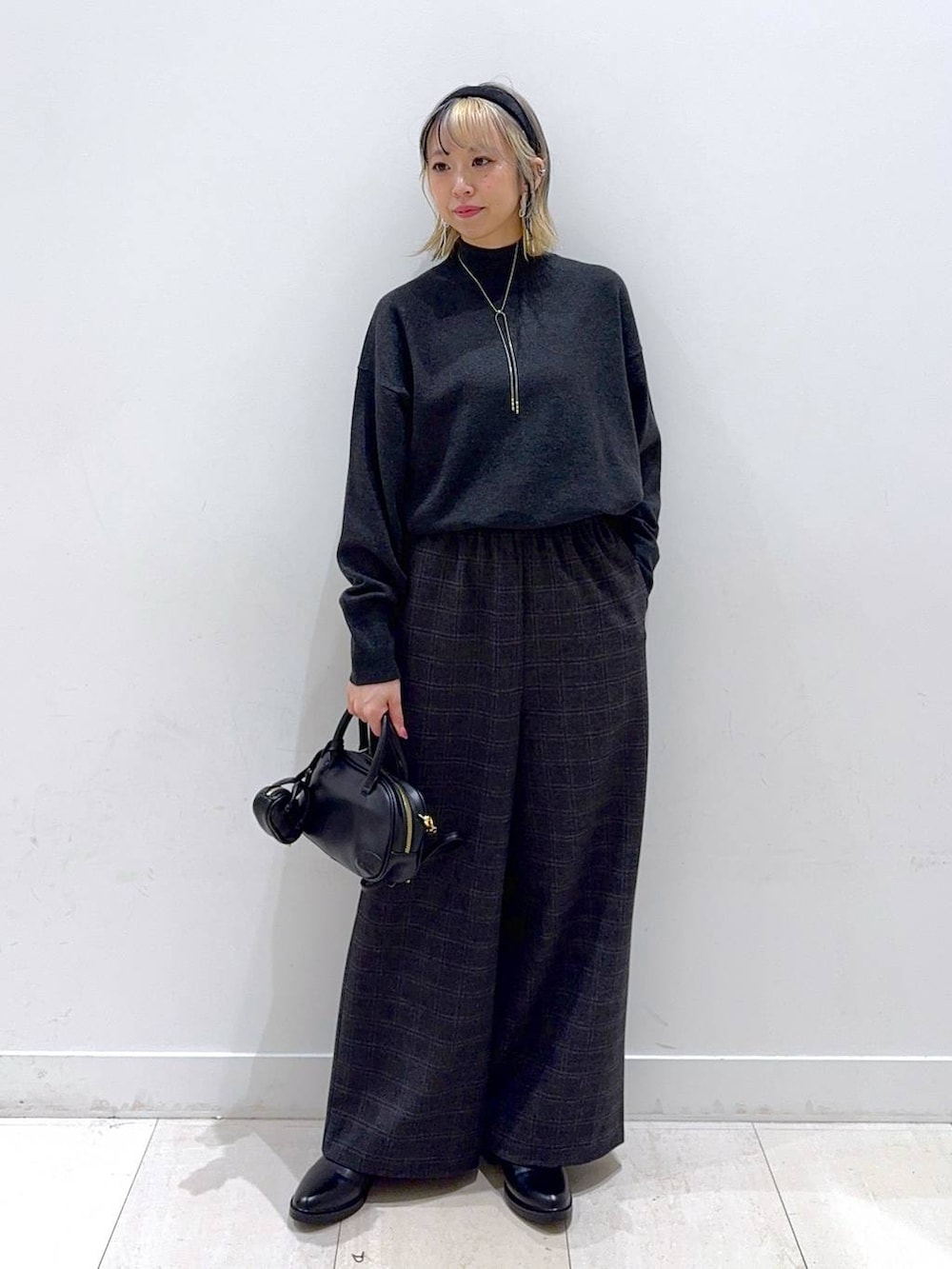 グレー系のニット/セーター、グレー系のその他パンツ、ブラック系のハンドバッグを着用したレディースの秋コーディネートの4枚目の写真