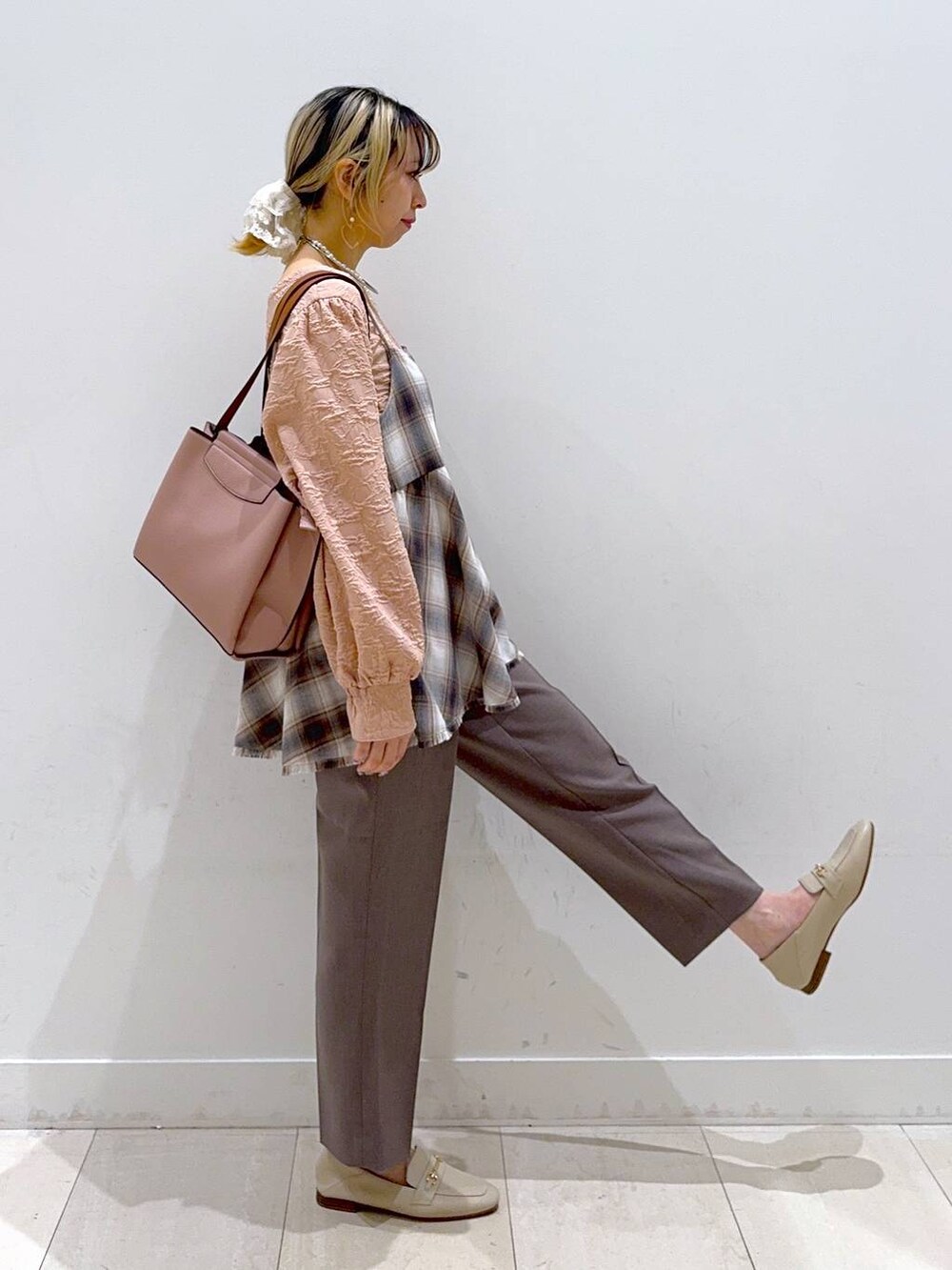 ピンク系のトートバッグ、ブラウン系のその他パンツ、ホワイト系のその他トップスを着用したレディースの春コーディネートの2枚目の写真