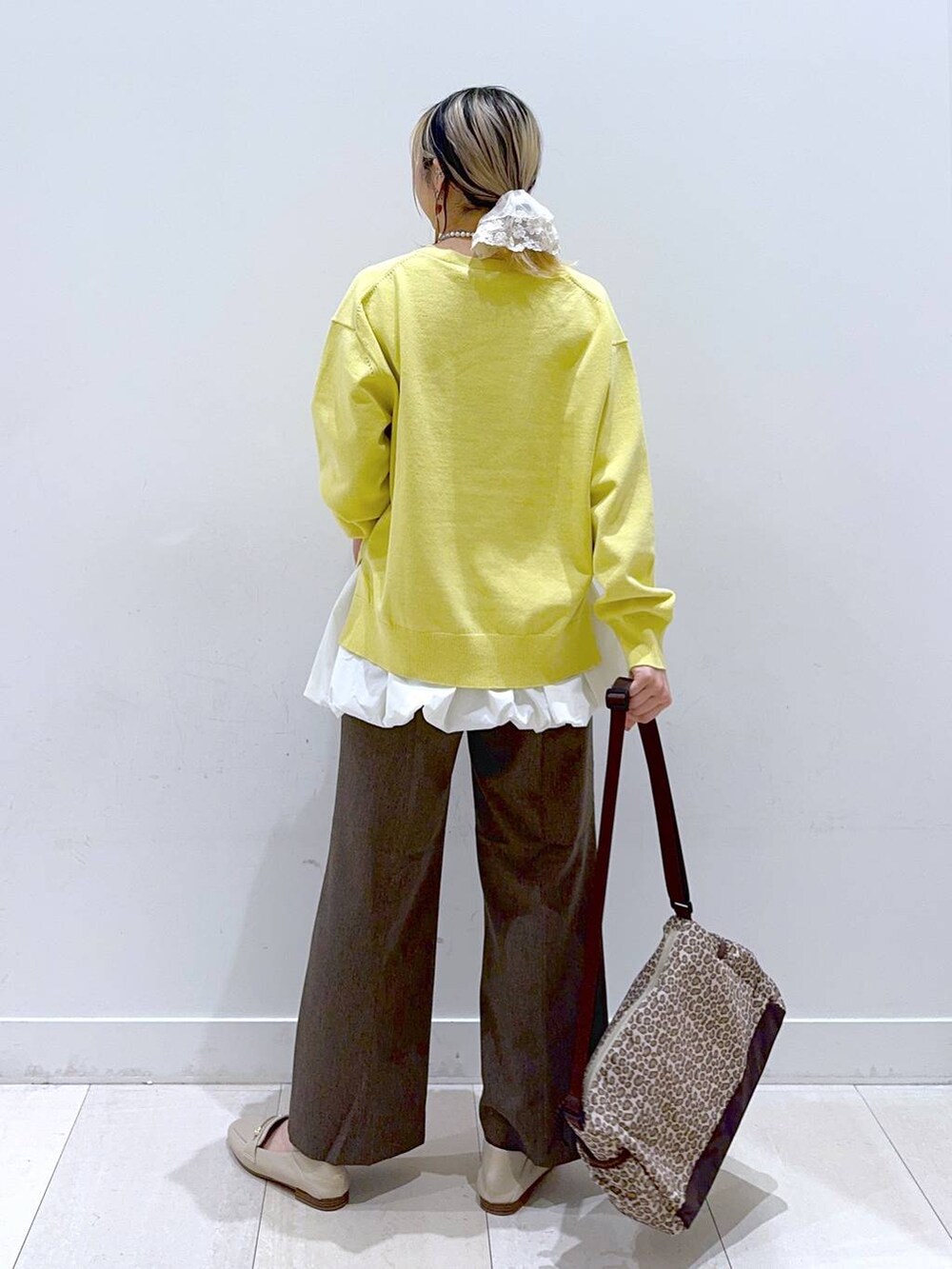 ブラウン系のその他パンツ、イエロー系のニット/セーター、ブラウン系のショルダーバッグを着用したレディースの春コーディネートの3枚目の写真