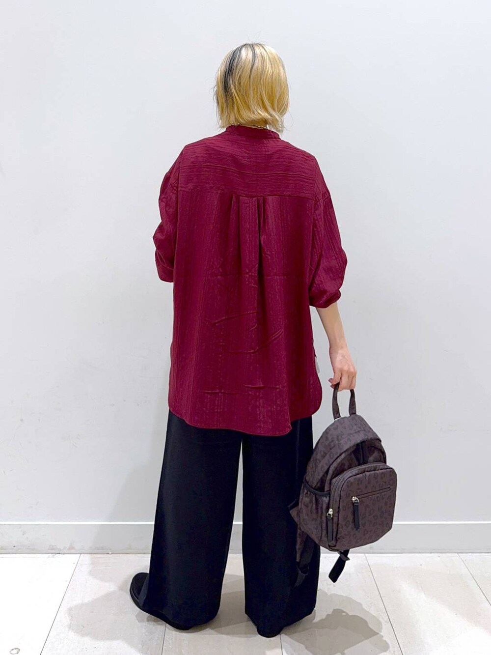 ブラウン系のバックパック/リュック、ブラック系のローファー、ブラック系のその他パンツを着用したレディースの秋コーディネートの3枚目の写真